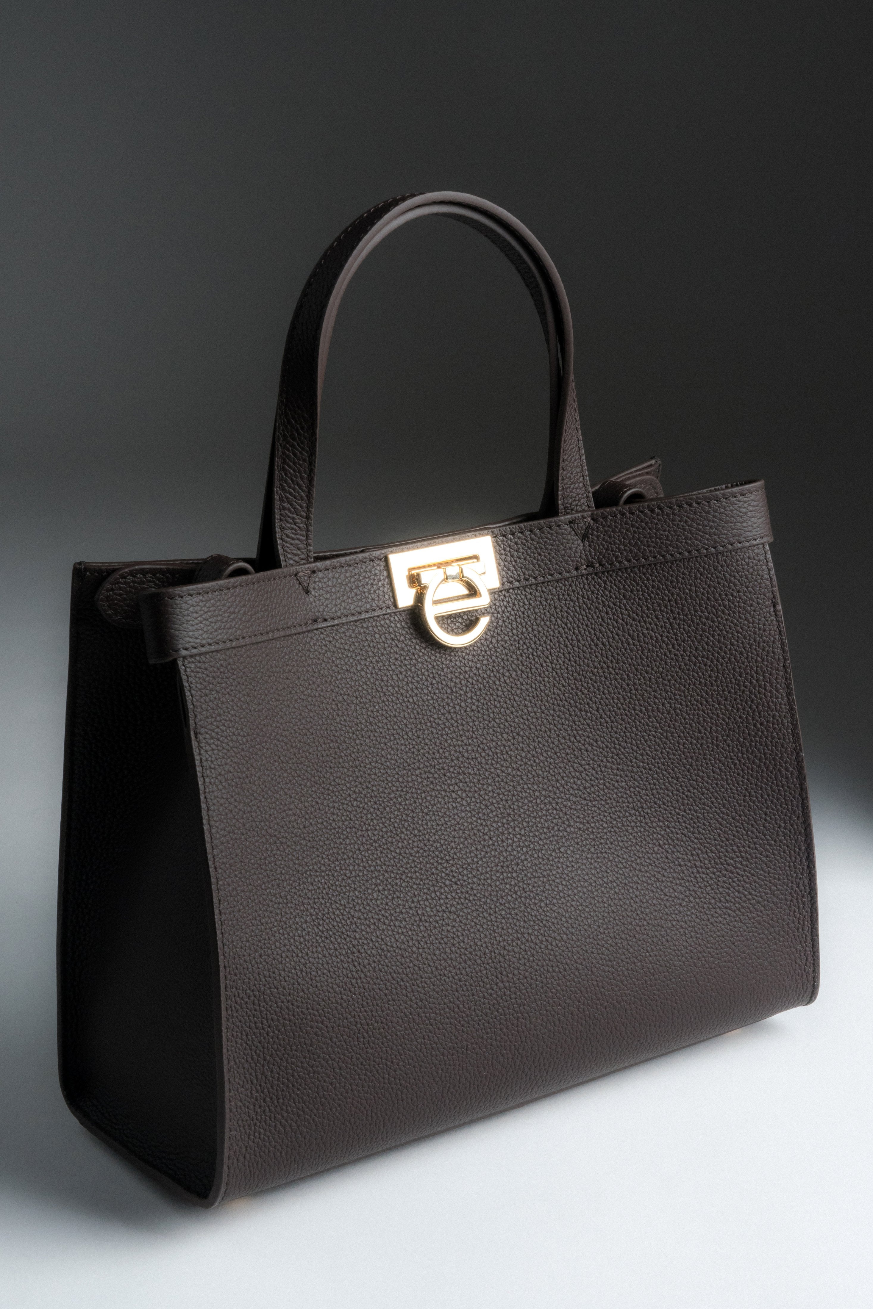 Schräge Frontansicht der dunkelbraunen Damen Tote-Bag aus Naturleder mit goldenem Verschluss.