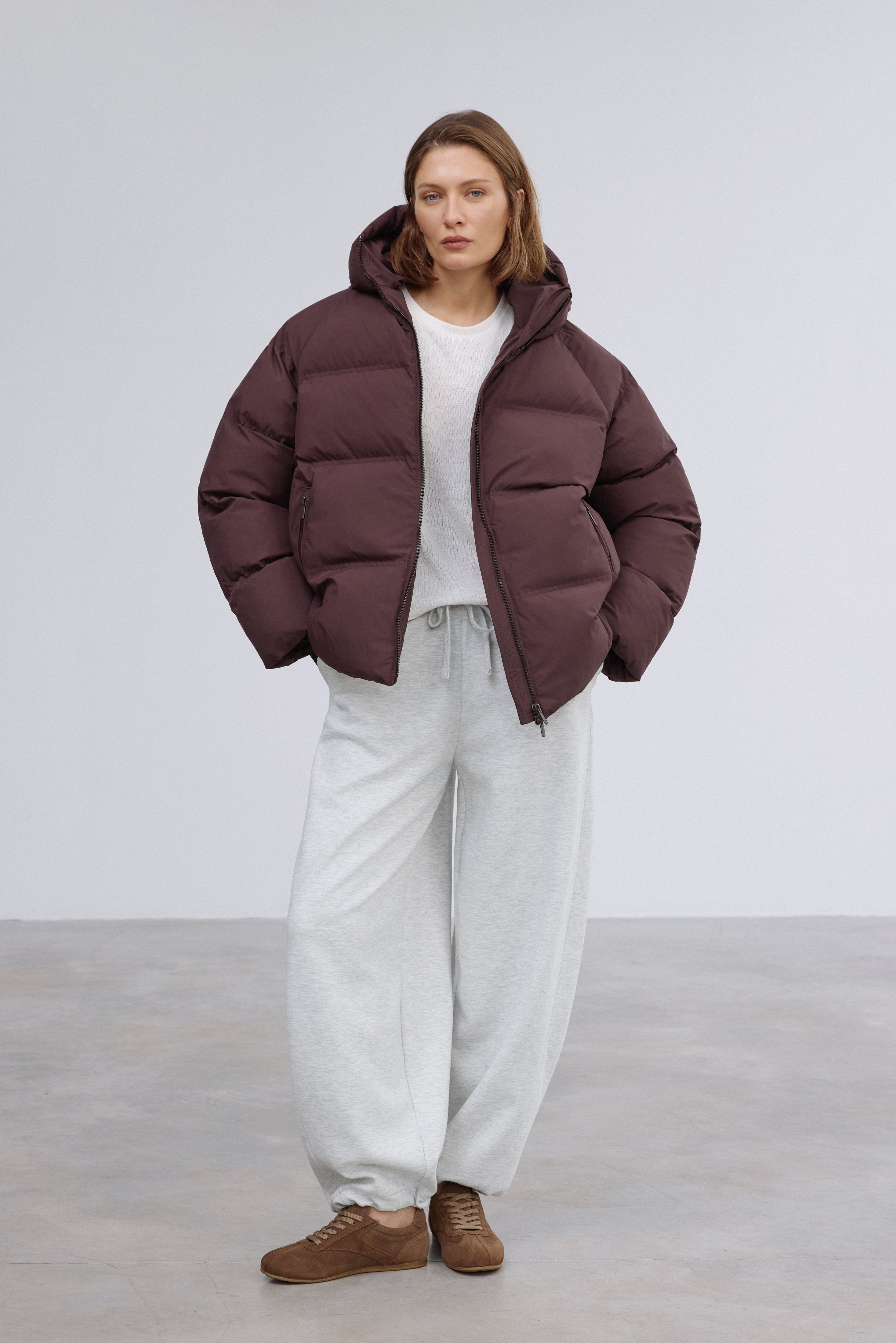 Frontale Silhouette in der dunkelbraunen gesteppten Winterjacke für Damen