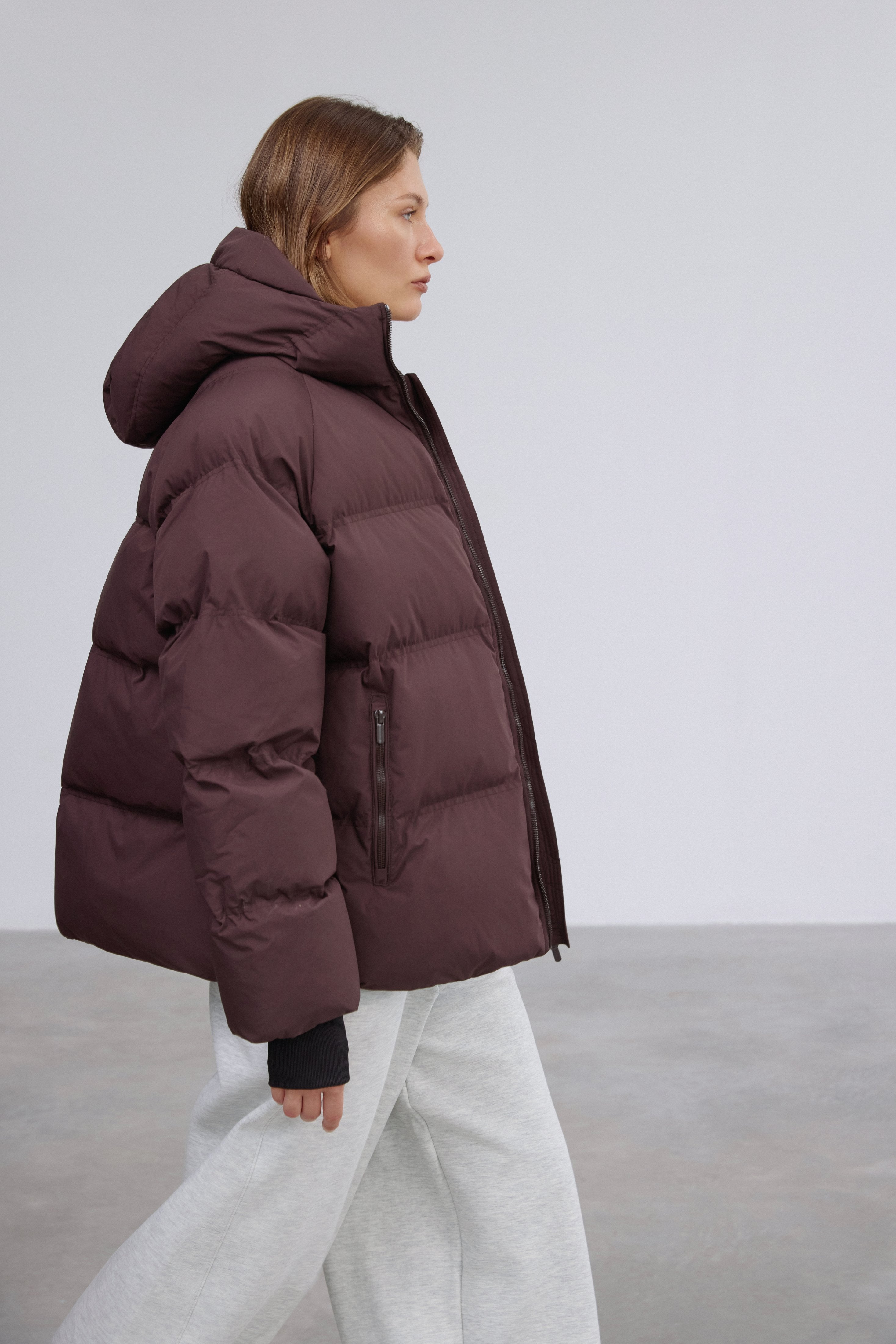 Flaches Seitenprofil der weiten dunkelbraunen Oversize-Winterjacke