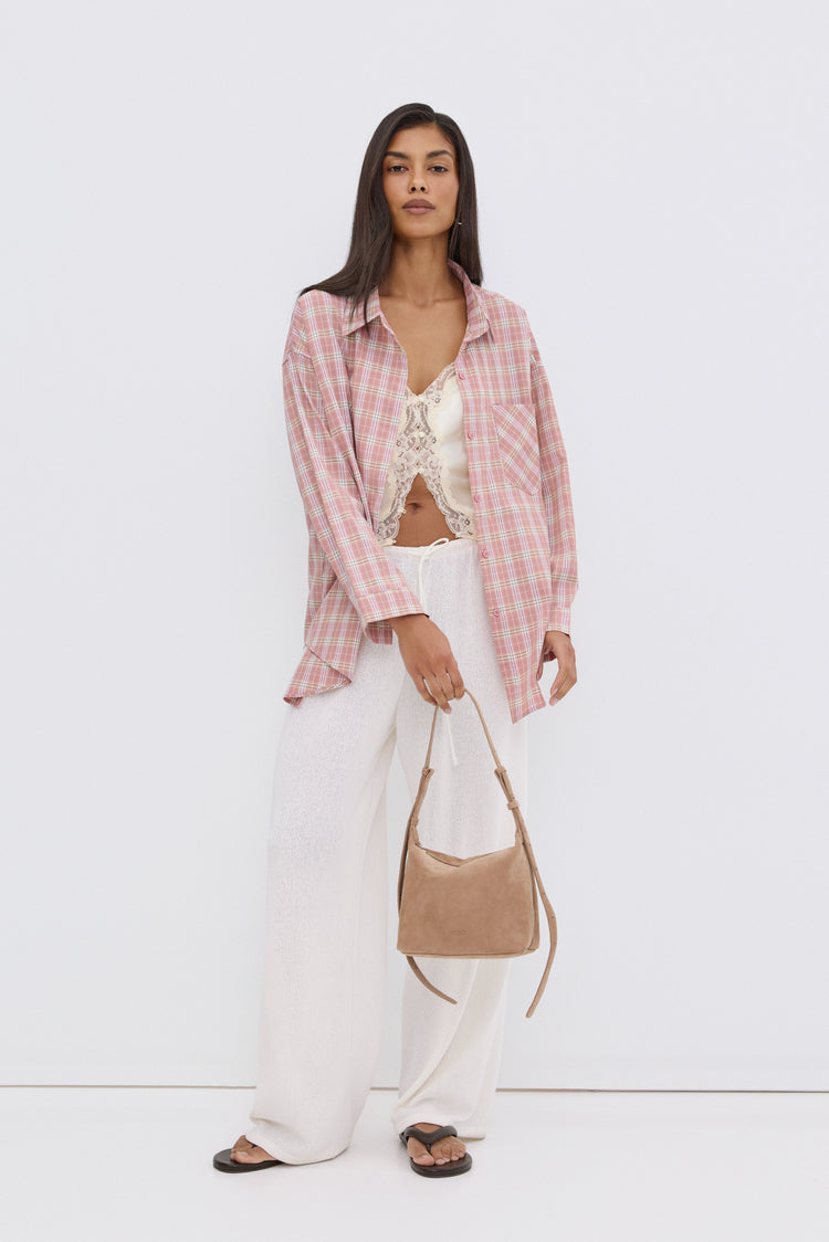 Model steht und präsentiert die dunkelbraunen Damen-Zehentrenner in einem legeren Sommer-Look