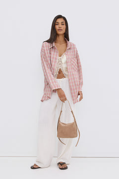 Model steht und präsentiert die dunkelbraunen Damen-Zehentrenner in einem legeren Sommer-Look