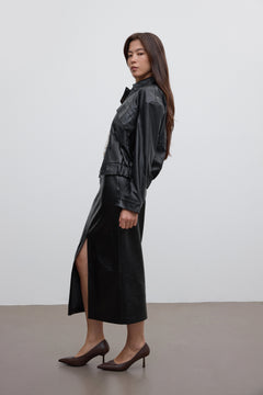 Model trägt die dunkelbraunen Stilettos zu einem eleganten schwarzen Outfit mit Midirock 