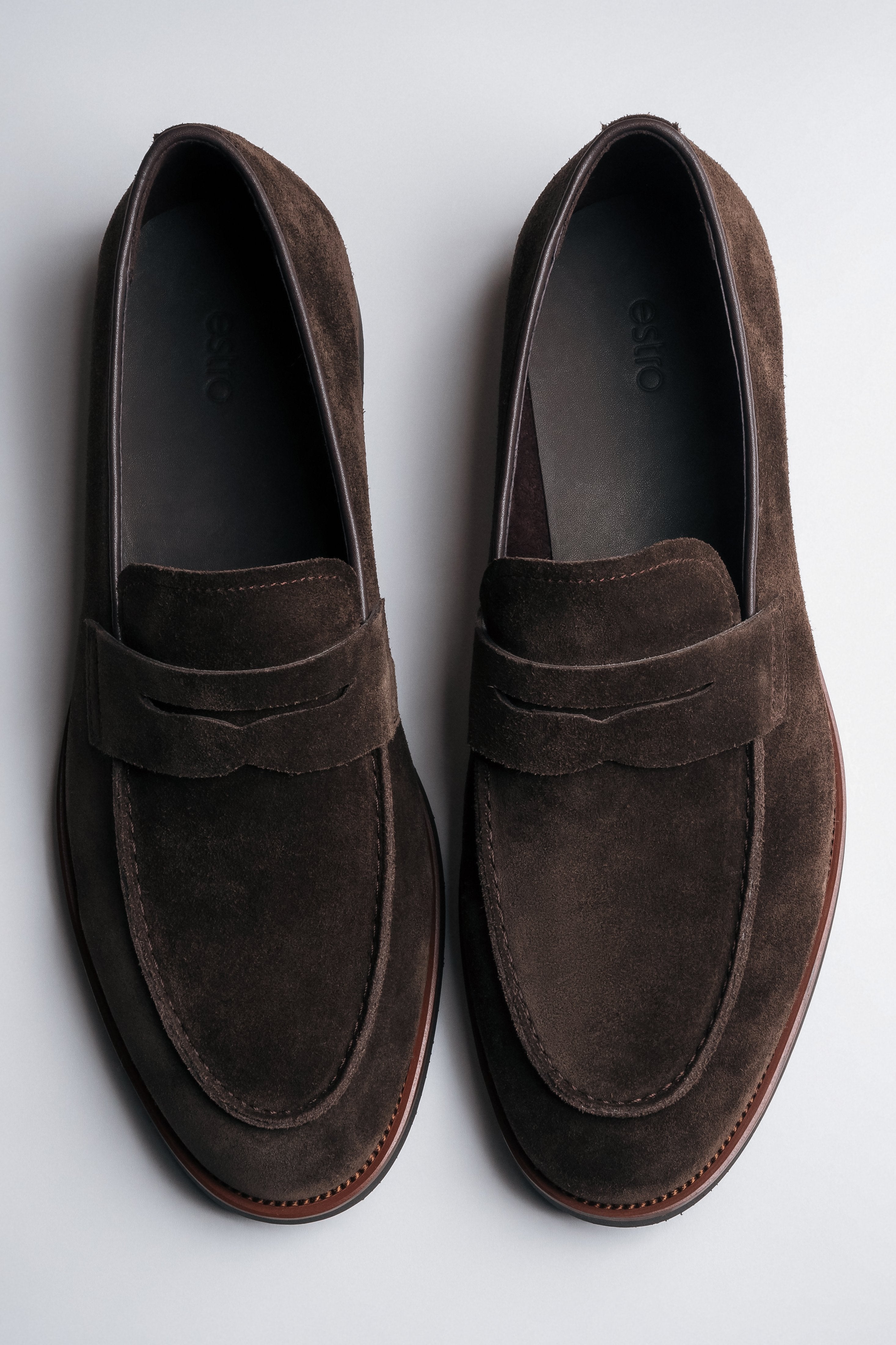 Draufsicht auf das Paar dunkelbrauner Herren-Loafer aus weichem Veloursleder.