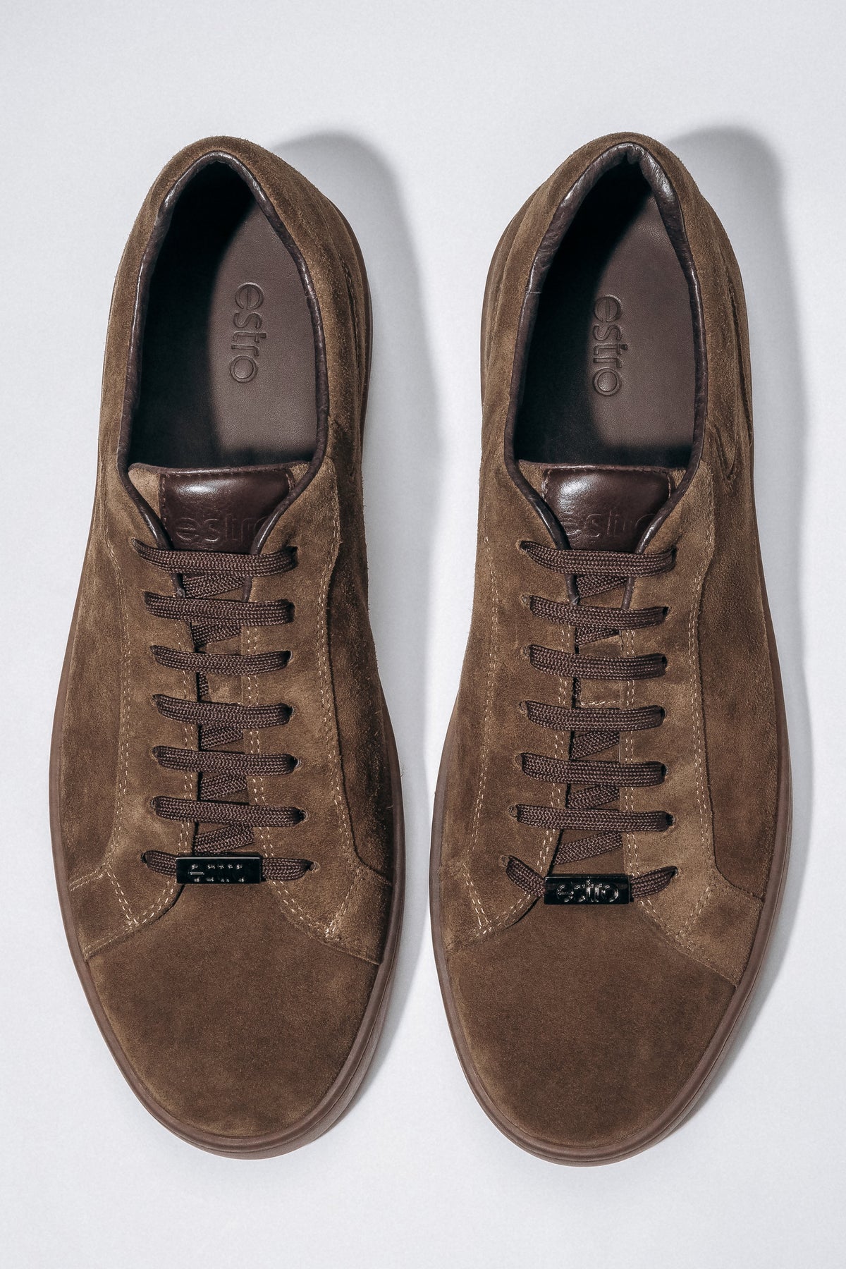 Draufsicht auf das Paar dunkelbrauner Herren-Sneaker aus weichem Veloursleder.