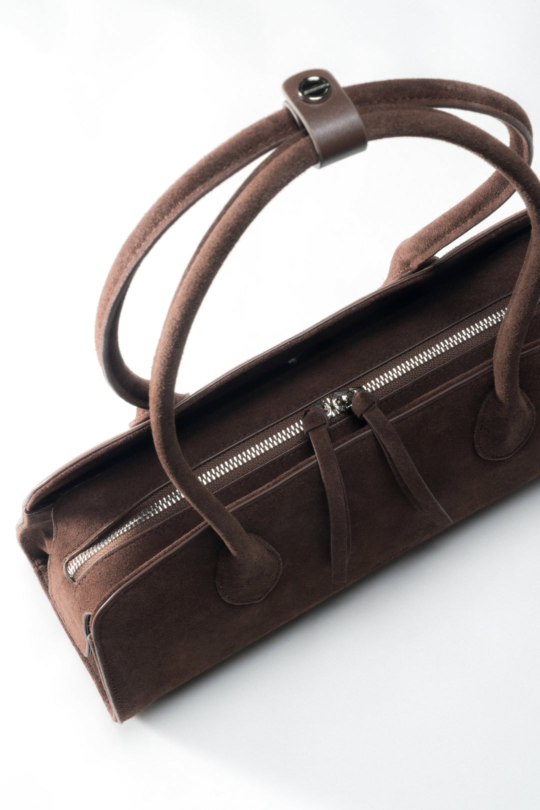 Ansicht der Henkel mit dem silbernen Pin, der die Riemen der Schultertasche zusammenhält.