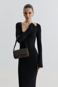 Model im schwarzen Kleid präsentiert die kleine dunkelbraune Ledertasche elegant über der Schulter getragen