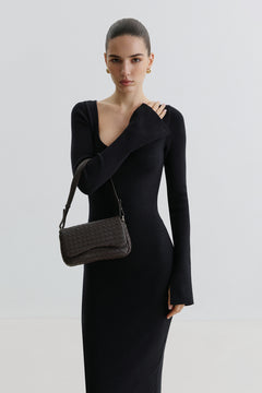 Model im schwarzen Kleid präsentiert die kleine dunkelbraune Ledertasche elegant über der Schulter getragen