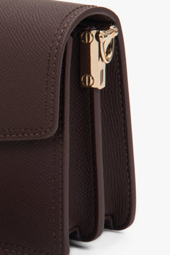 Zeitlose dunkelbraune Schultertasche z verstellbarem Riemen i goldfarbenen Metallelementen.