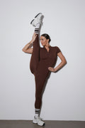 Dunkelbrauner Damen-Sport-Jumpsuit mit langen Beinen und kurzen Ärmeln in der Vorderansicht.