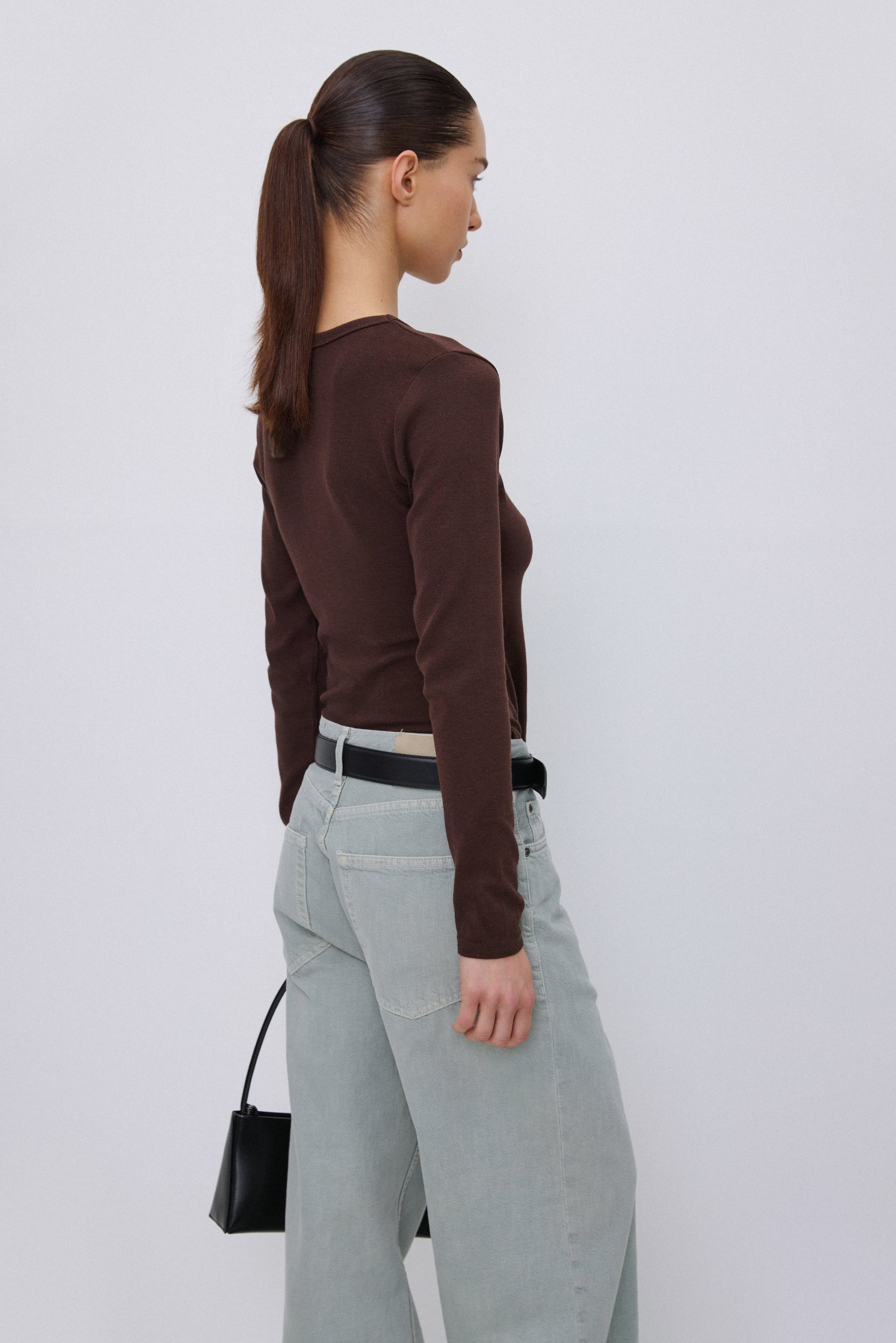 Seiten- und Rückansicht des braunen Basic-Shirts, das die figurbetonte Passform verdeutlicht.