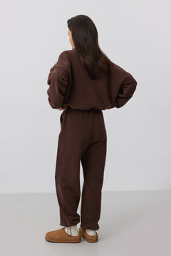 Rückansicht des Models in dem dunkelbraunen Fleece-Set, die den entspannten Loose Fit zeigt