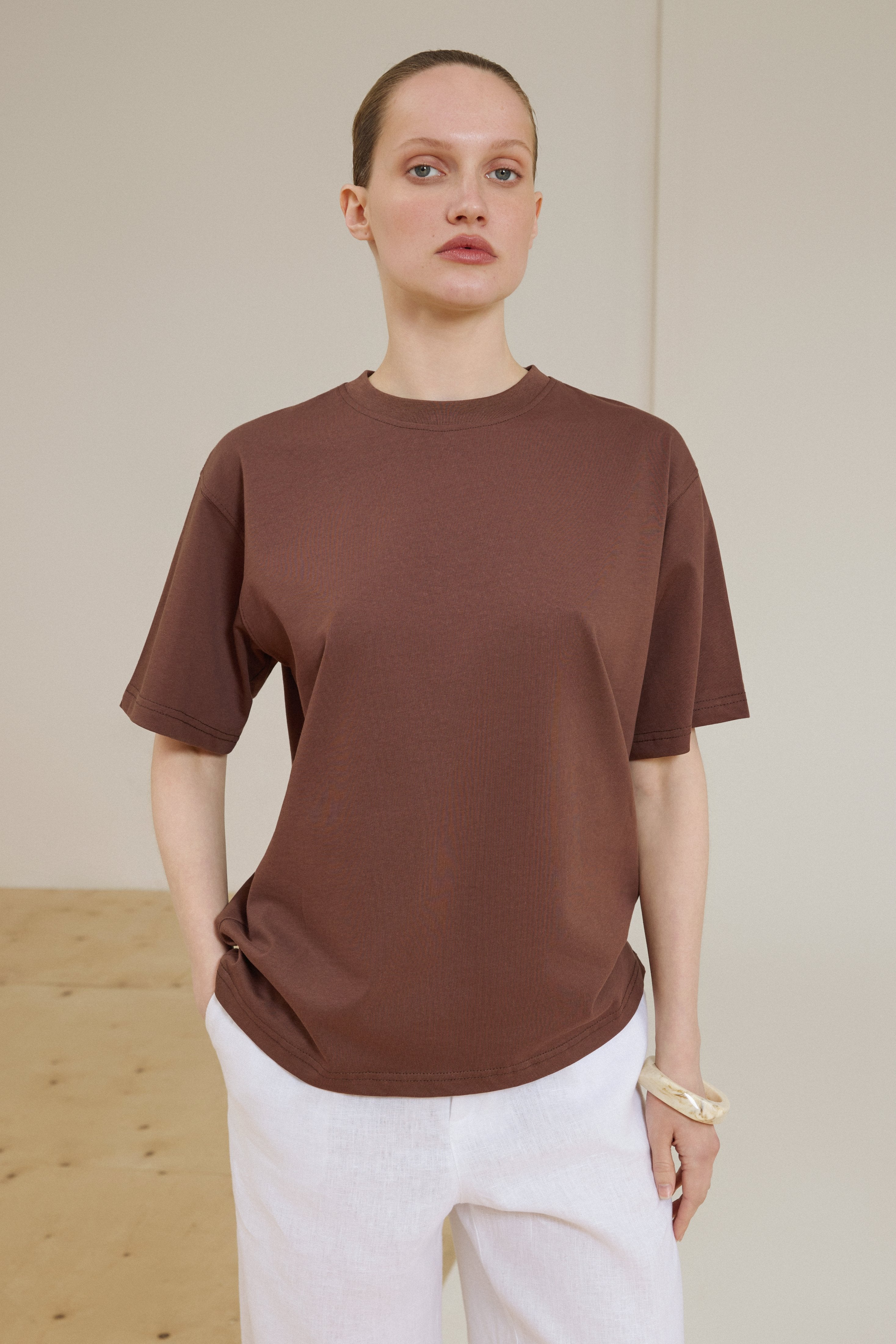 Model trägt dunkelbraunes Damen-T-Shirt aus Baumwolle in voller Länge