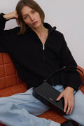 Model trägt die elegante schwarze Schultertasche aus Echtleder zu einem lässigen Outfit mit Jeans 