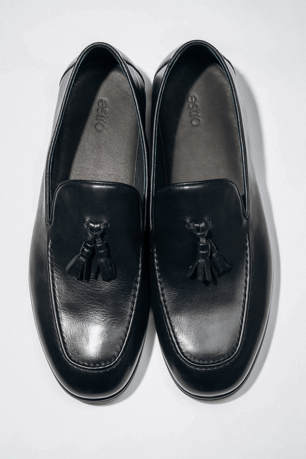 Draufsicht auf das Paar elegante schwarze Herren-Loafer mit Quaste.