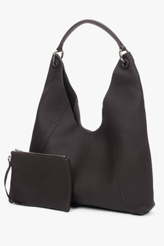 Die dunkelbraune Ledertasche wird zusammen mit der praktischen, herausnehmbaren Kosmetiktasche präsentiert.