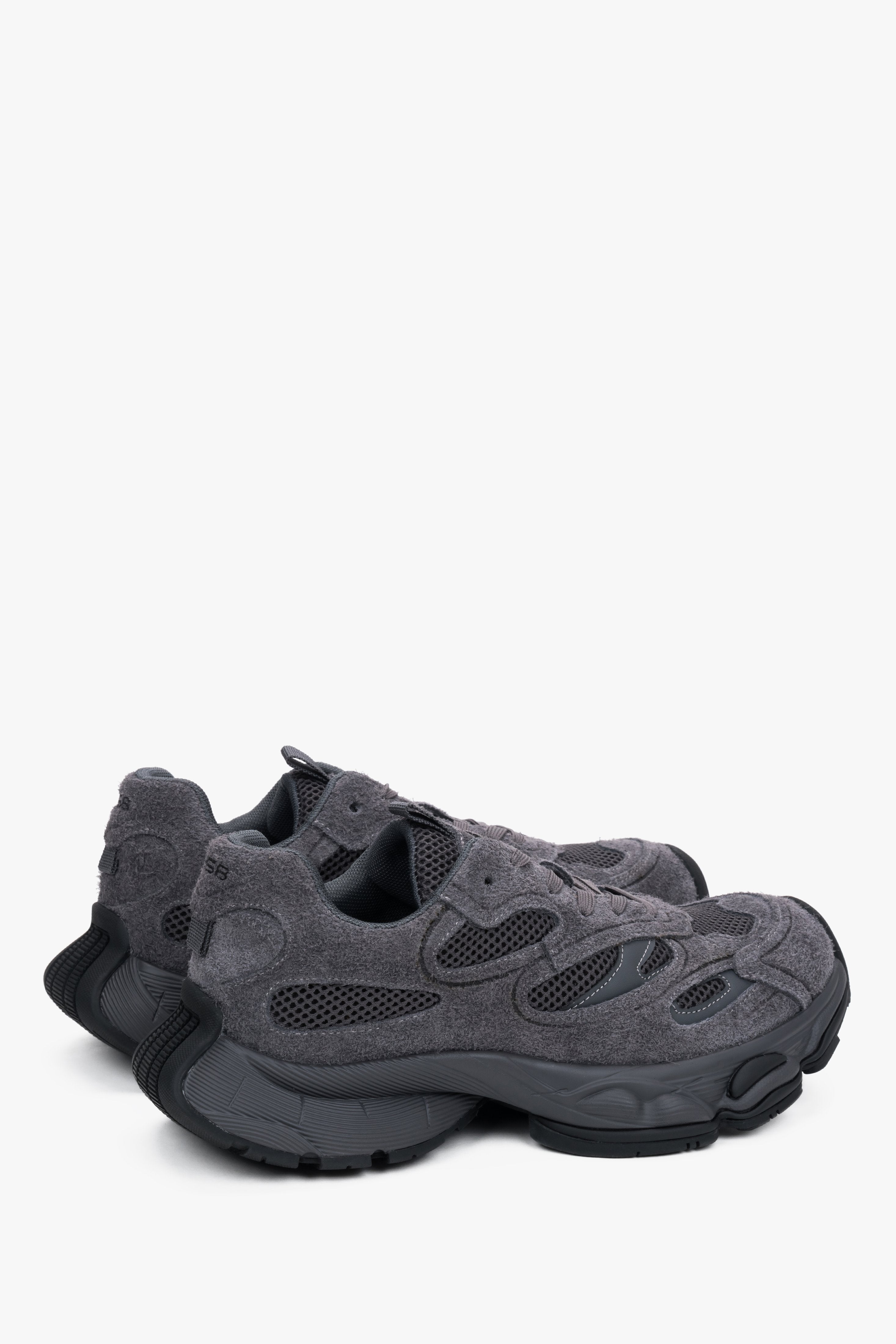 Rückwärtige Schrägansicht der Sneaker mit Fokus auf die klobige Fersenpartie und die profilierte Sohle 