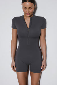 Grauer, kurzer Damen-Sport-Jumpsuit Slim Fit in der Vorderansicht.