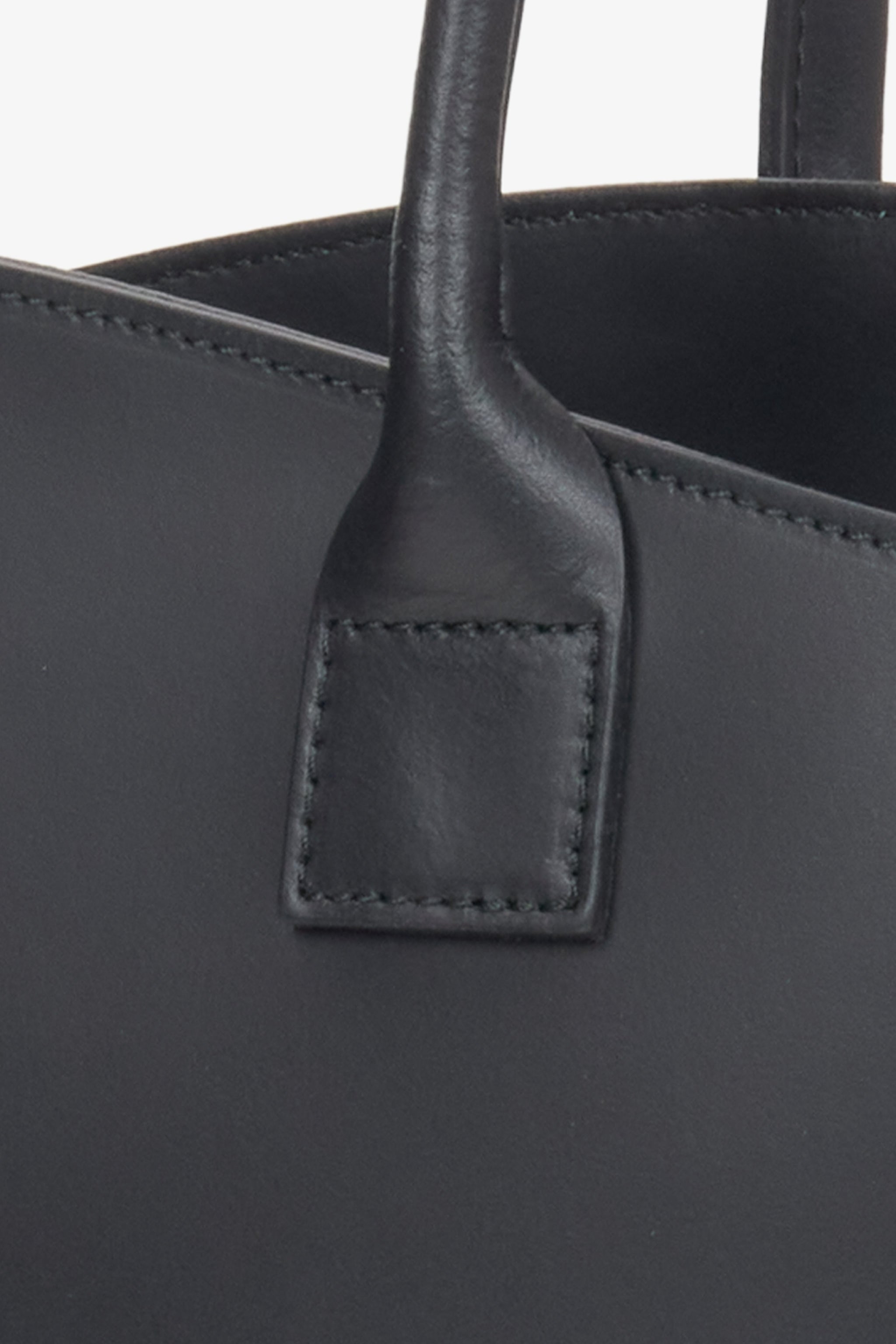 Detailaufnahme der genähten Griffbefestigung aus schwarzem Leder