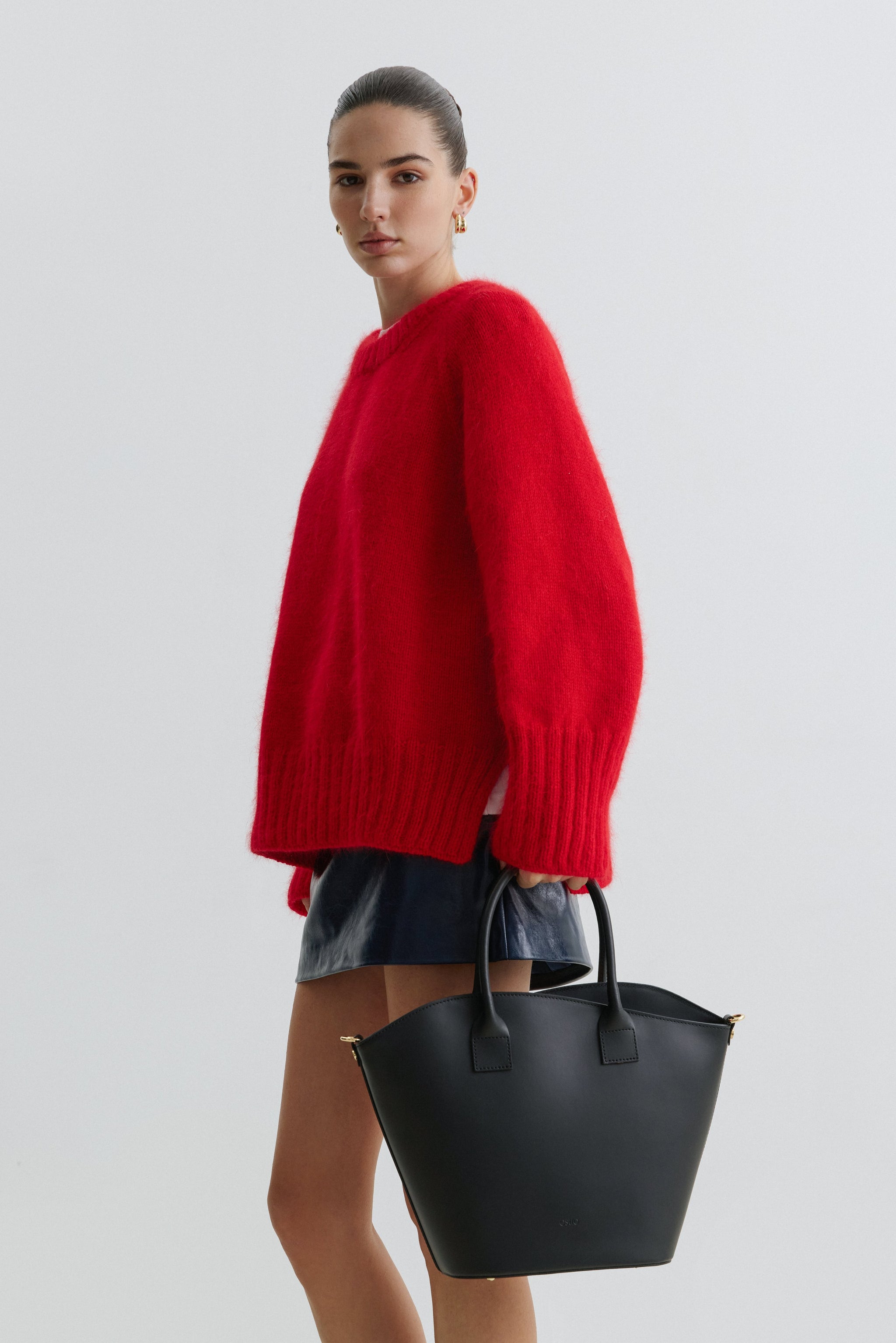 Model in voller Größe mit der schwarzen Ledertasche in der Hand