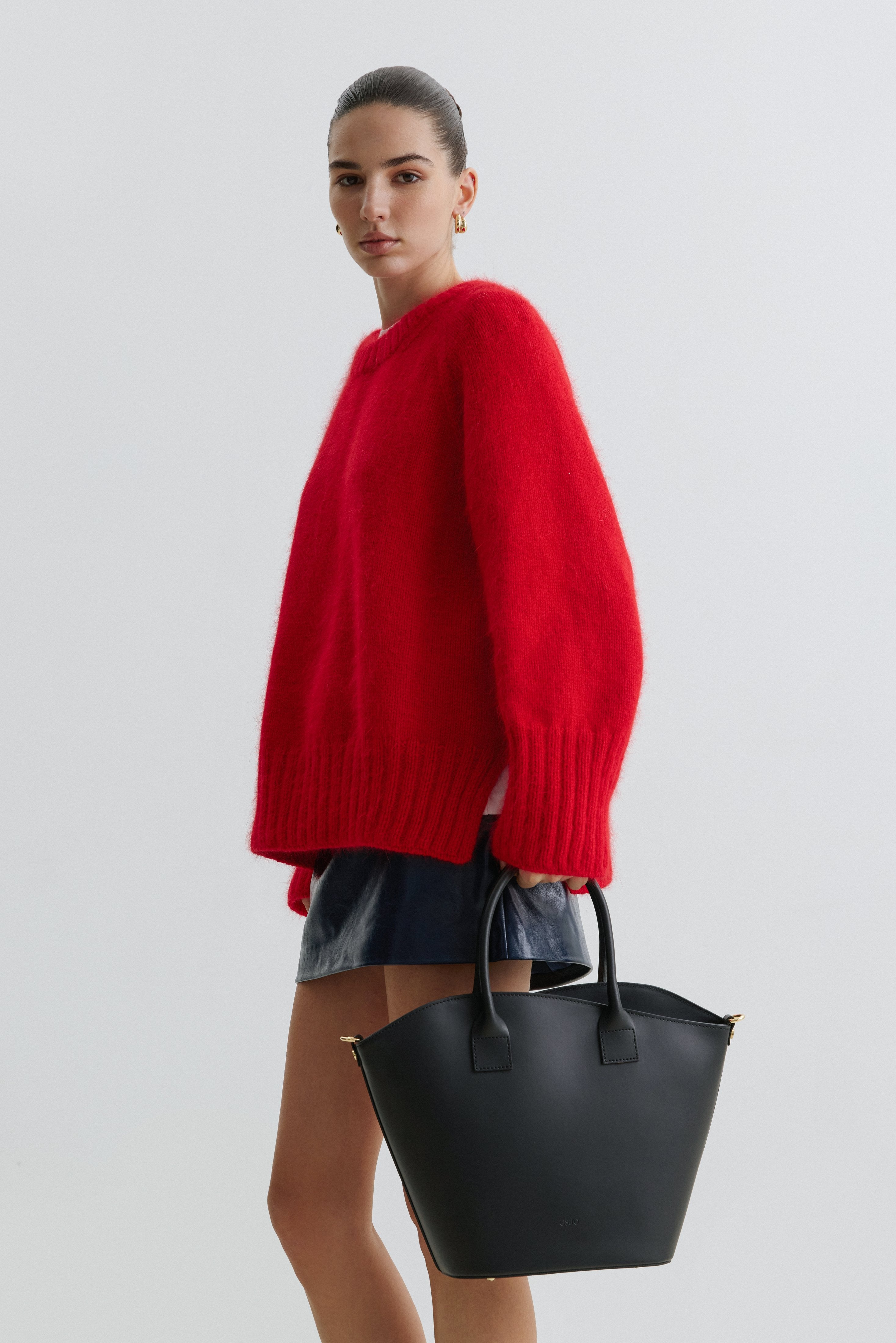 Model in voller Größe mit der schwarzen Ledertasche in der Hand