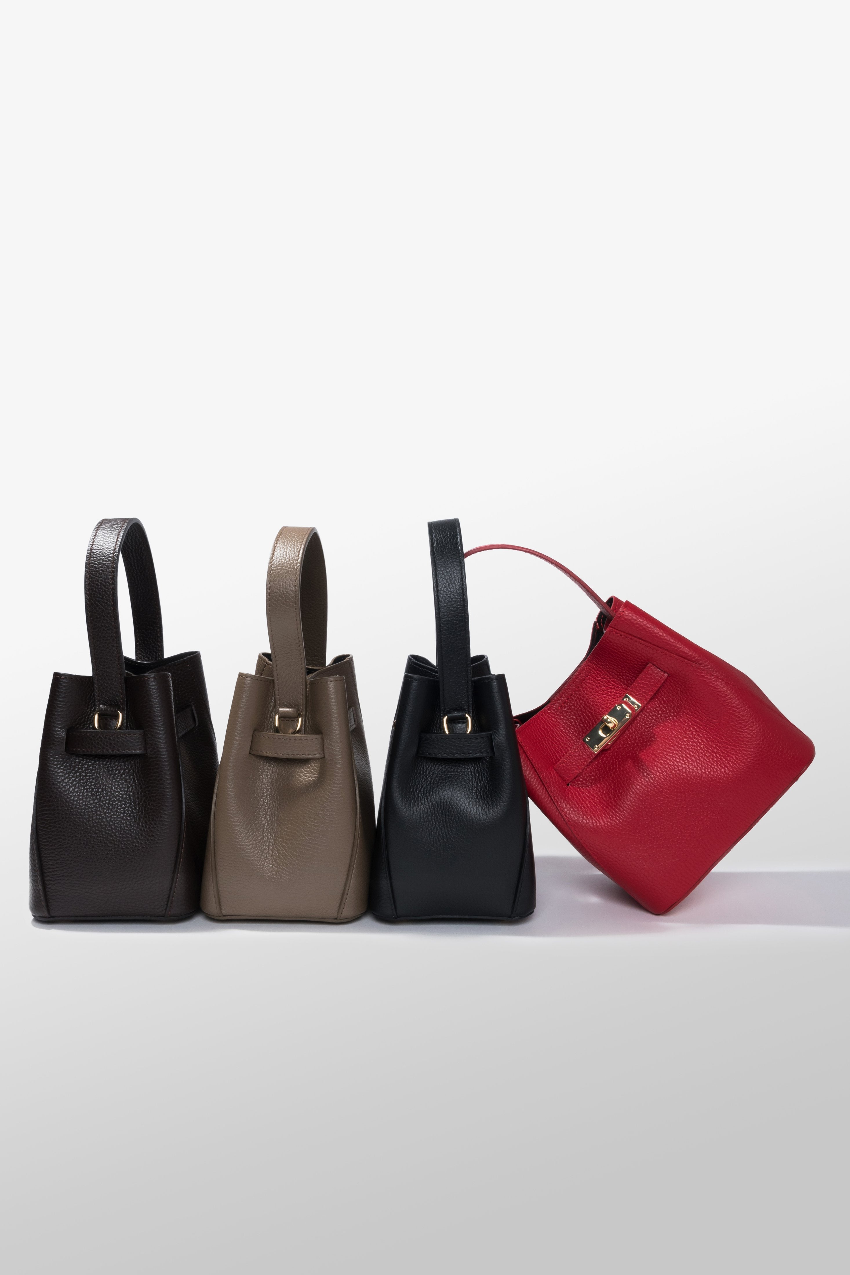 Gruppenaufnahme der eleganten Satchel Bags aus der Kollektion in verschiedenen Erdtönen und ausdrucksstarkem Rot 