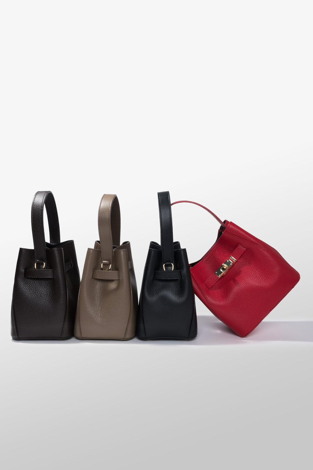 Gruppenaufnahme der eleganten Satchel Bags aus der Kollektion in verschiedenen Erdtönen und ausdrucksstarkem Rot 