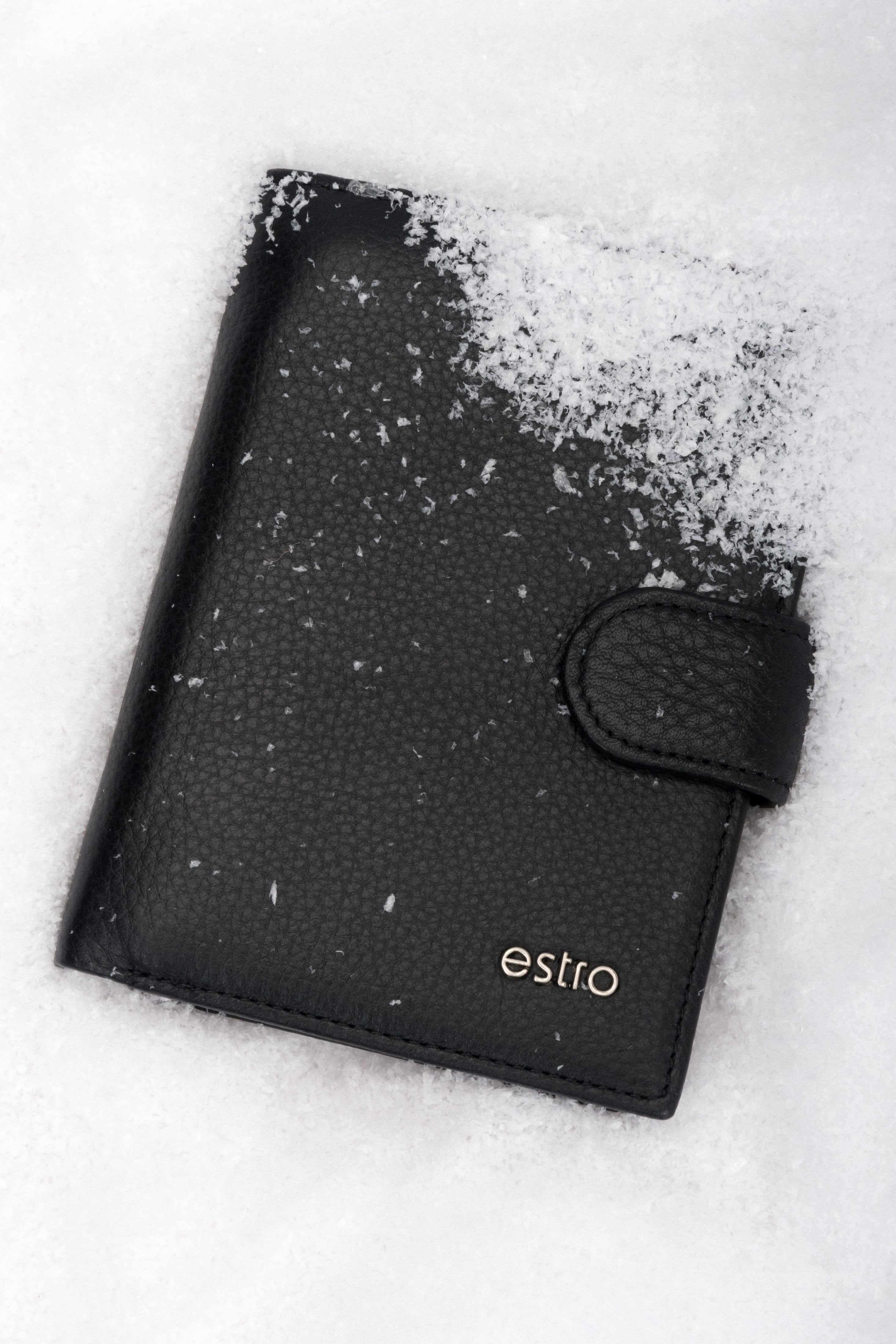 Frontalansicht der handlichen schwarzen Herren-Geldbörse aus Echtleder mit Druckknopfverschluss im Schnee.
