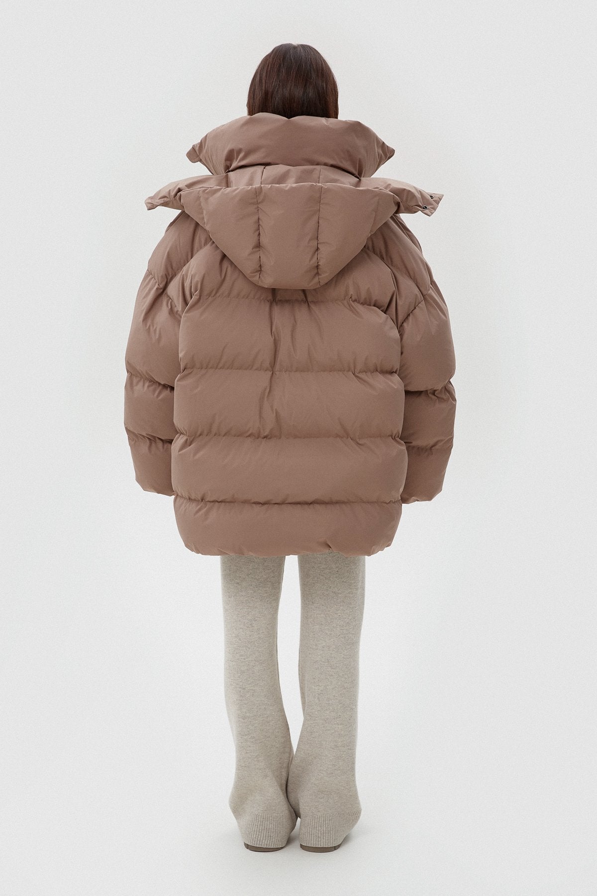 Rückansicht der weiten hellbeigen Winterjacke mit Kapuze