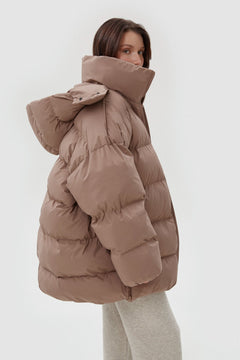 Seitliches Profil der Oversize-Pufferjacke in sanftem Beigeton