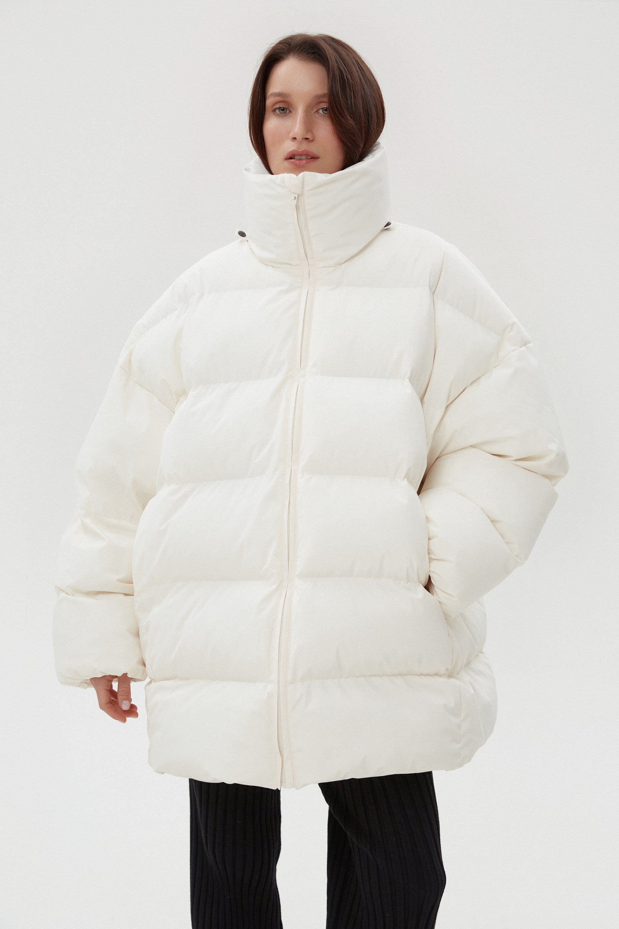 Frontalaufnahme der geschlossenen hellbeigen Winterjacke mit hohem Stehkragen