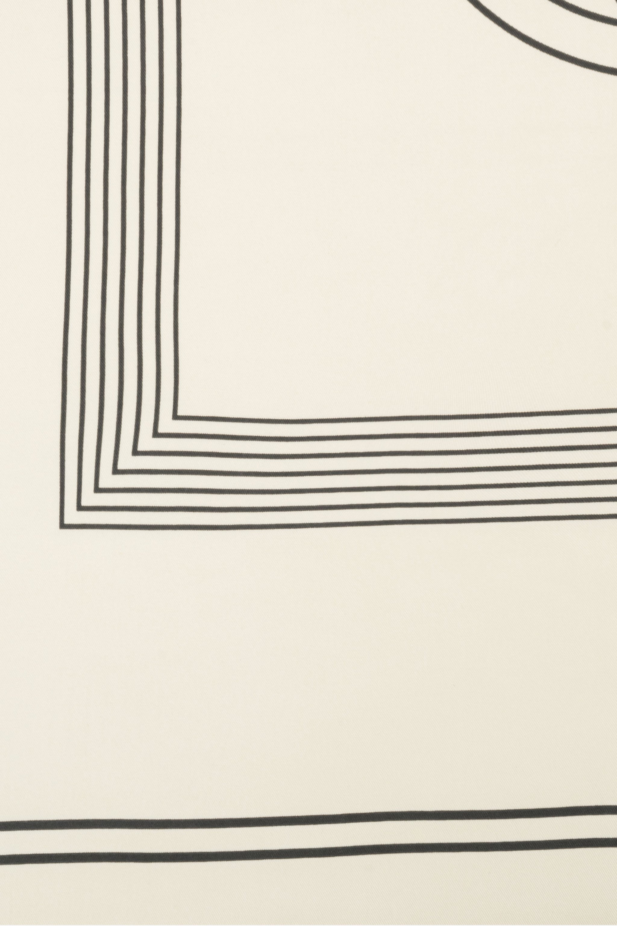 Nahaufnahme des dezenten geometrischen Musters und der schwarzen Linien auf dem hellbeigen Stoff 