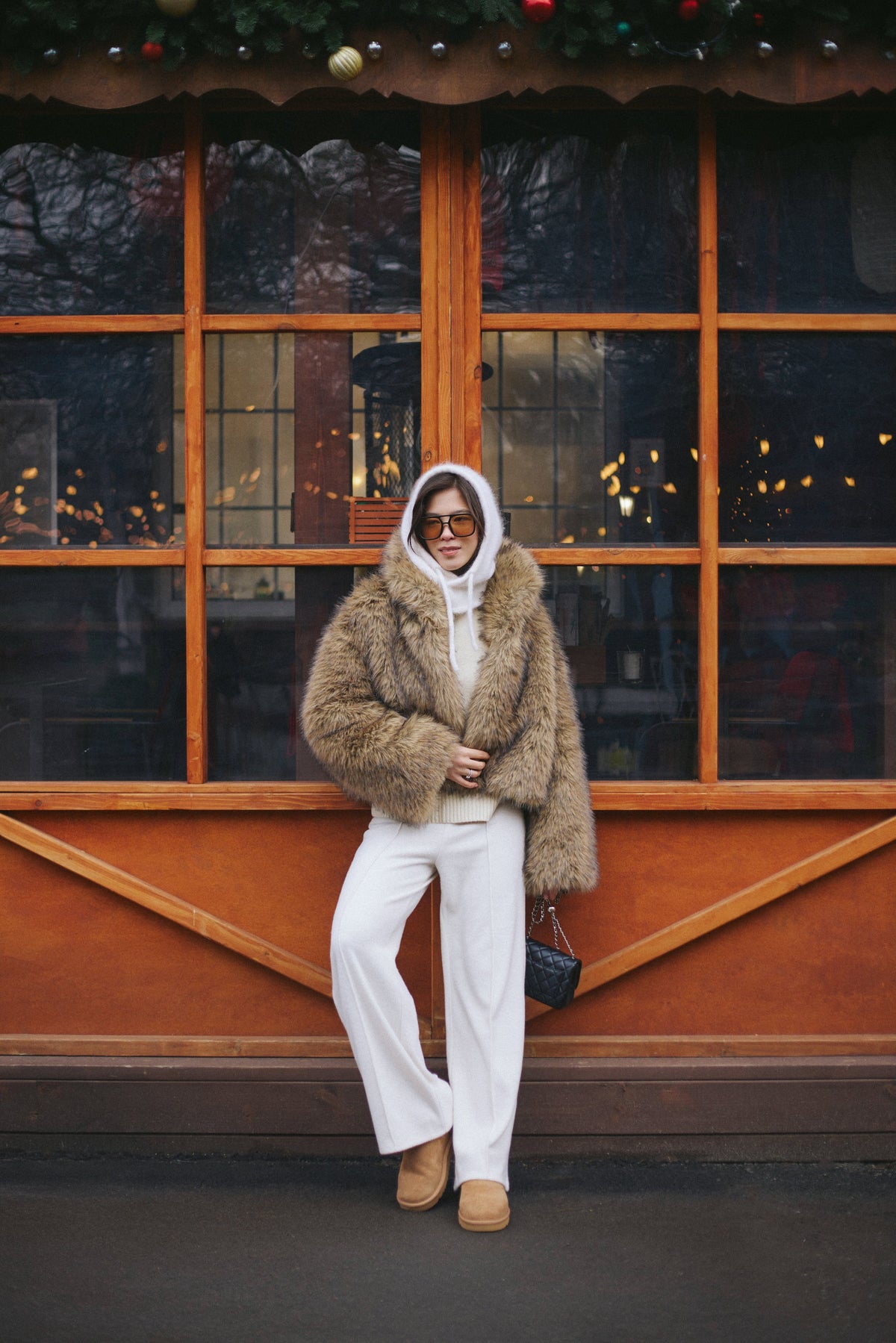 Outdoor-Lifestyle-Aufnahme des Models im hellbeigen Fleece-Set mit einem markanten gelben Schal