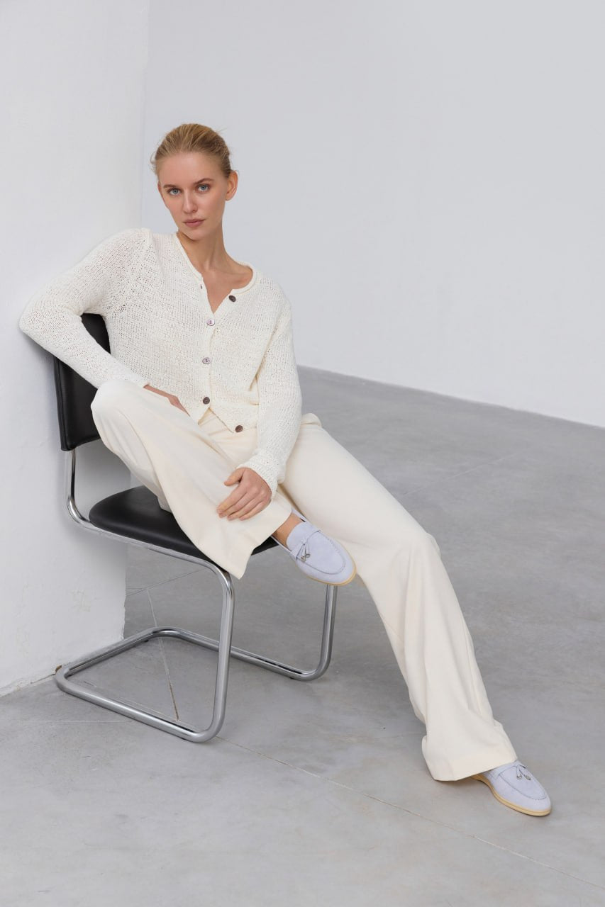 Hellblaue Velours-Mokassins getragen von einem Model zum weißen Outfit.