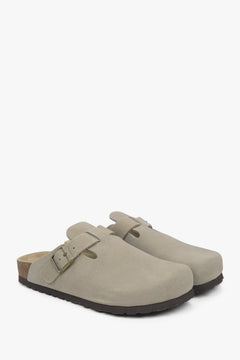 Schräge Ansicht des Paares hellgrauer Velours-Clogs mit Schnalle.