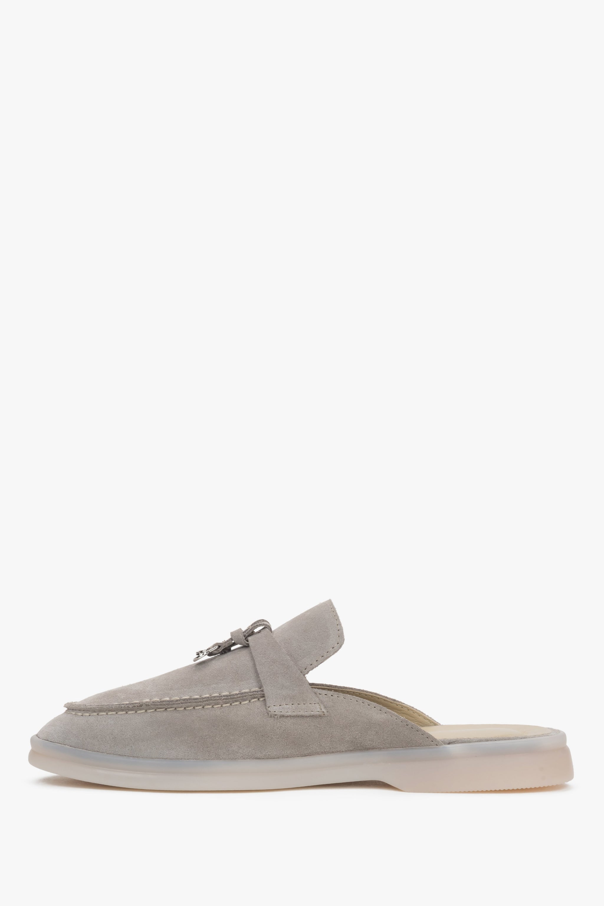 Profilansicht der hellgrauen Mules mit Fokus auf die flache Sohle und das elegante Design.
