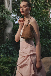 Model trägt kleine beige Damen-Beuteltasche aus echtem Velours mit Kordelzug