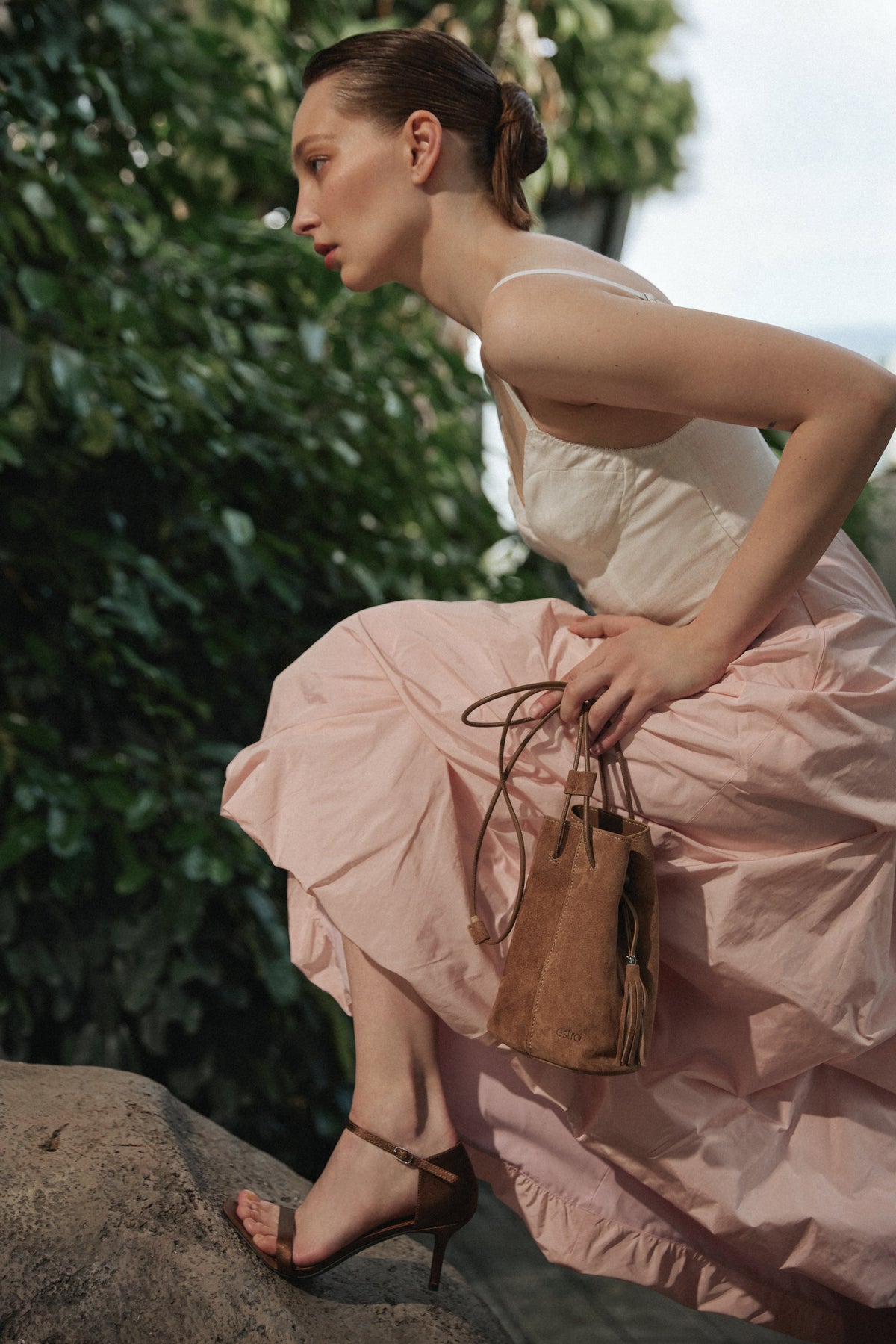 Model trägt kleine beige Velours-Beuteltasche zu sommerlichem Outfit