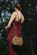 Das Model präsentiert die beige Estro Beuteltasche aus Veloursleder als elegante Schultertasche.