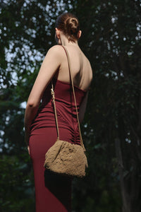 Das Model präsentiert die beige Estro Beuteltasche aus Veloursleder als elegante Schultertasche.