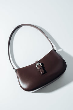 Schräge Aufsicht auf die dunkelbraune Damen-Schultertasche aus Glattleder mit silberner Schnalle