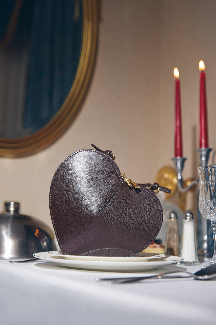 Stimmungsvolle Lifestyle-Aufnahme der Herztasche auf einem elegant gedeckten Tisch