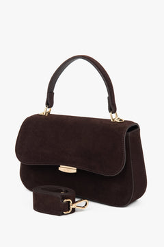 Diagonale Ansicht der dunkelbraunen Satchel-Tasche aus Veloursleder mit angebrachtem breitem Schulterriemen