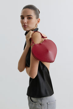 Lifestyle-Aufnahme eines Models, das die rote Herztasche stilvoll über der Schulter trägt