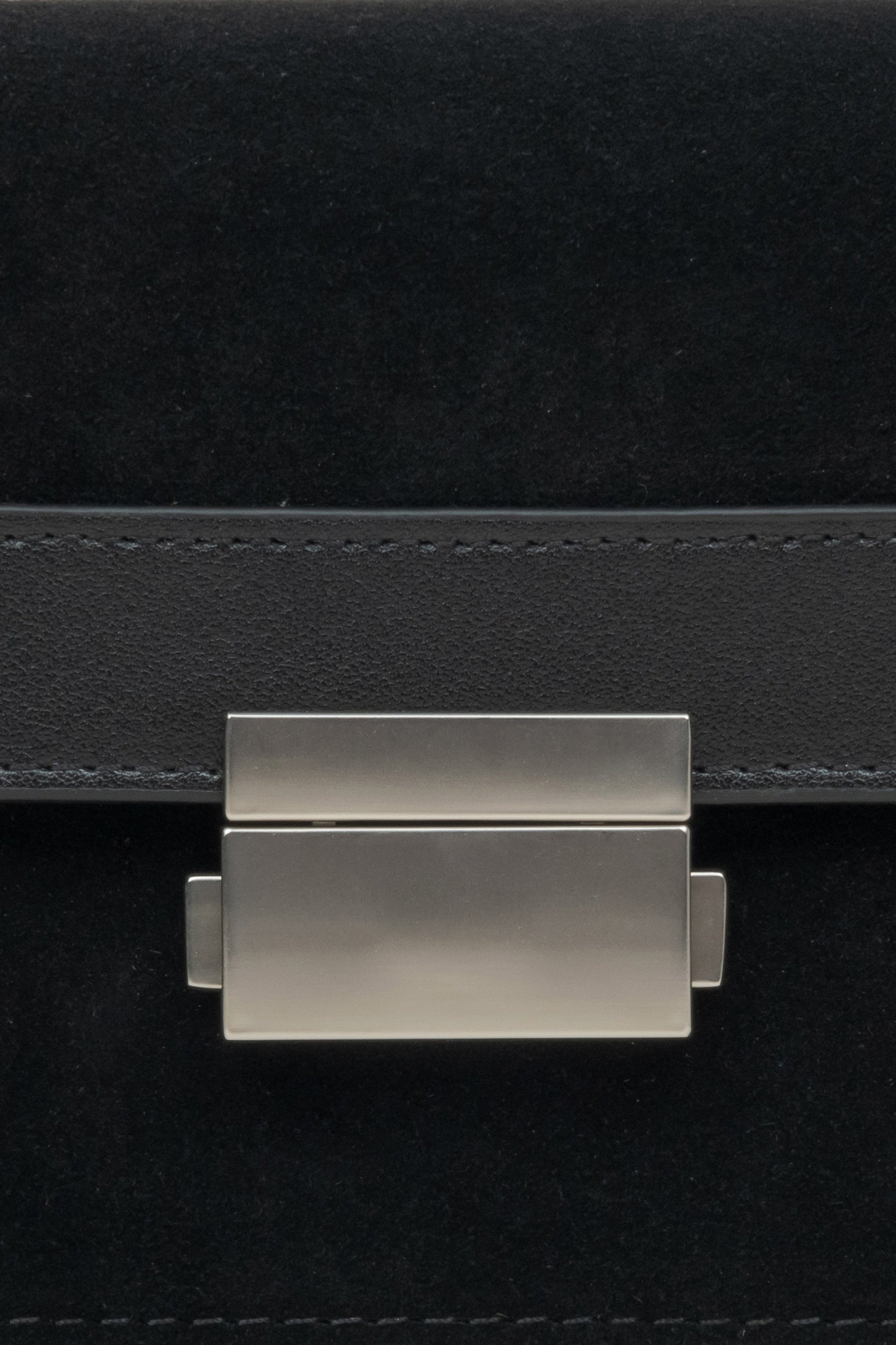 Kompakte Damenhandtasche aus Leder und Velours in Schwarz – Nahaufnahme eines Details.