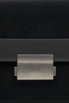 Kompakte Damenhandtasche aus Leder und Velours in Schwarz – Nahaufnahme eines Details.
