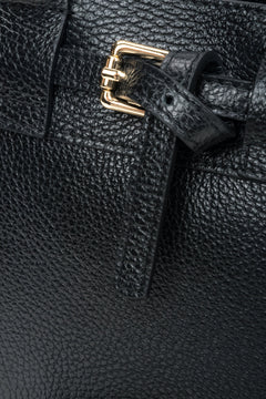 Detailansicht der goldfarbenen Schnalle an schwarzer Estro Henkeltasche.