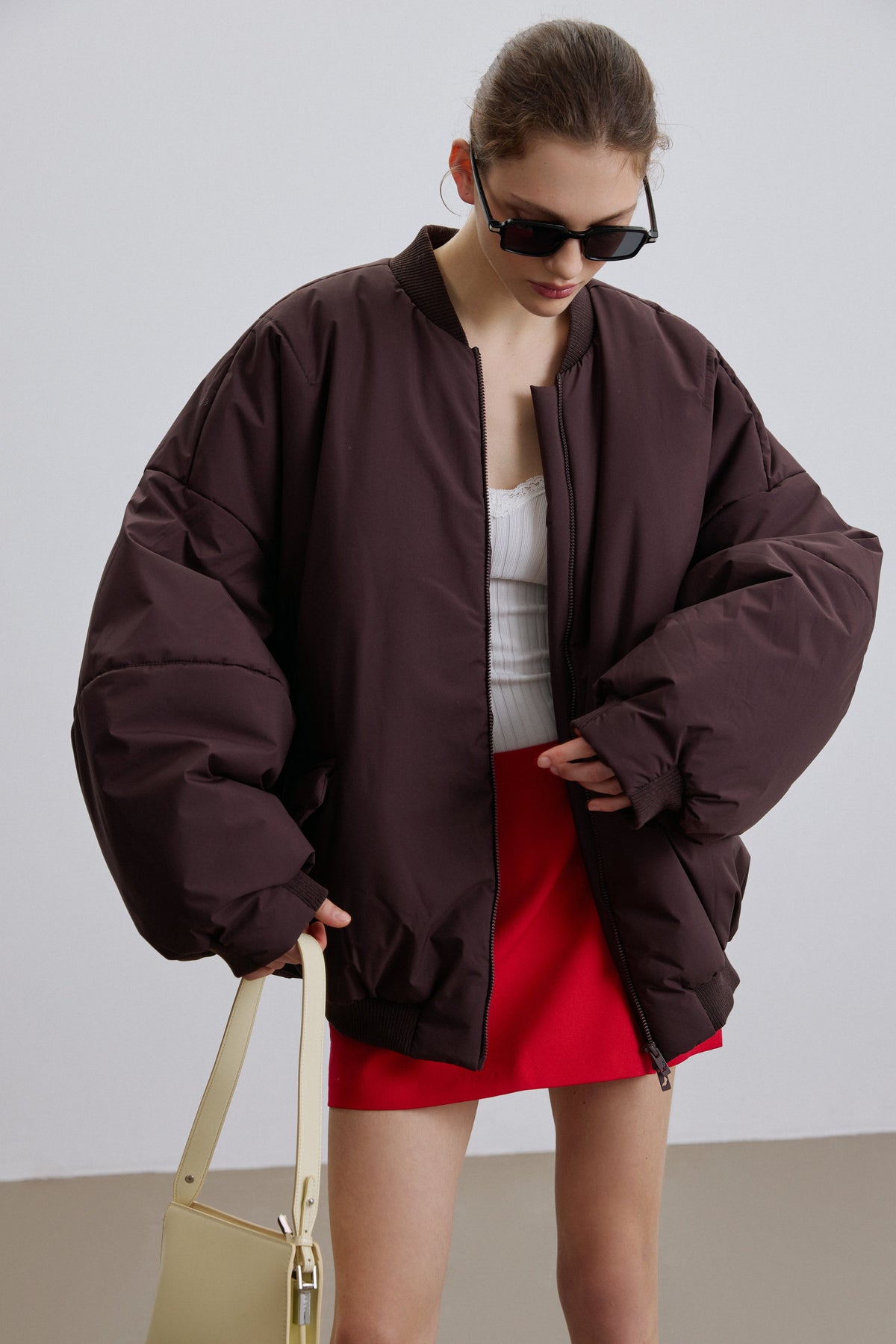Frontansicht der dunkelbraunen Oversize-Bomberjacke für Damen am Model.