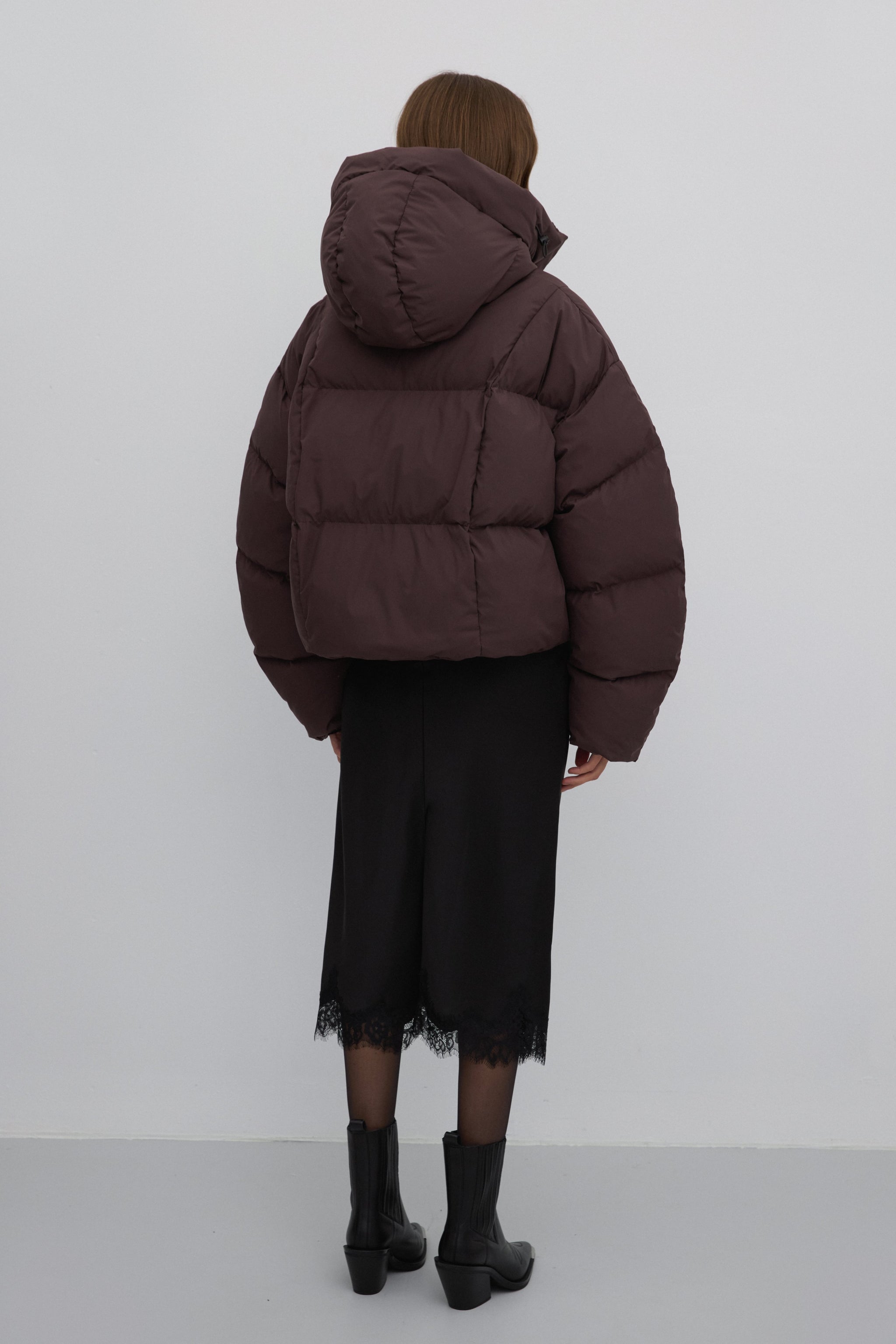 Rückansicht der dunkelbraunen Damen-Pufferjacke, die den kastigen Oversize-Schnitt zeigt