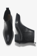 Künstlerische Draufsicht auf das Paar der kurzen schwarzen Cowboystiefel aus Echtleder