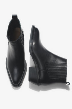 Künstlerische Draufsicht auf das Paar der kurzen schwarzen Cowboystiefel aus Echtleder
